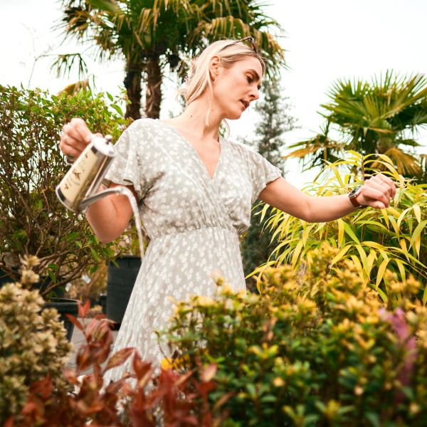 Eine Person gießt Blumen im Garten